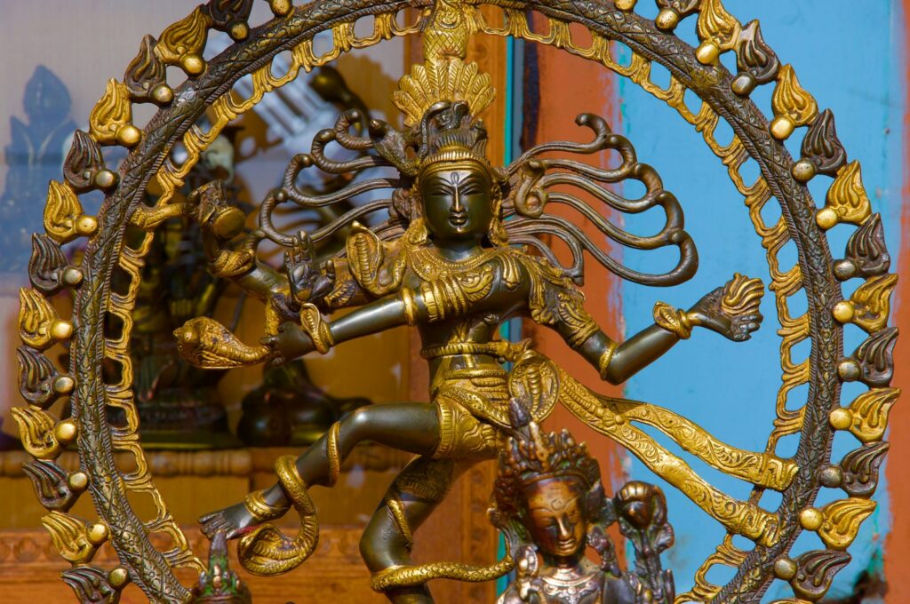 a statue of a woman dancing in front of a clock